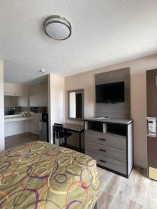 a hotel room with a bed and a flat screen tv at Garden Inn & Suites in Hogansville