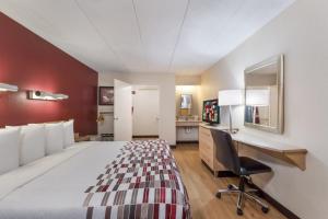 Habitación de hotel con cama y escritorio en Red Roof Inn Philadelphia - Trevose en Trevose