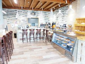 a restaurant with a counter with bar stools at ALBERGUE VALIN LAMA in Palas de Rei