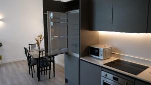 a small kitchen with a table and a microwave at MK shortstay Deluxe- Capital Drive in Milton Keynes +14 photos