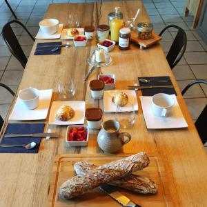 a wooden table with plates of food on it at La Demeure de Cyr 