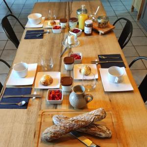 a wooden table with plates of food on it at La Demeure de Cyr in Saint-Chamant +49 photos