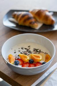 a bowl of yogurt with fruit and raisins on a table at Moro Inn in Korčula