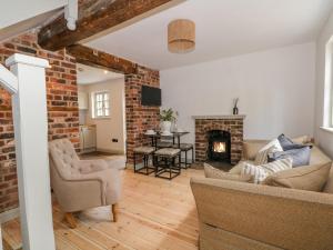 a living room with a couch and a fireplace at The Coach House in Crewe