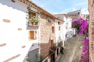 Une ruelle de la ville positano avec des fleurs violettes dans l'établissement Casa Montesa, à Vilafamés
