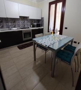 eine Küche mit einem Esstisch mit Stühlen und einer Küche in der Unterkunft Casa Stella in Torre Grande