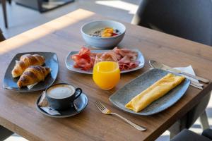 a table with plates of breakfast food and a cup of coffee at Moro Inn in Korčula