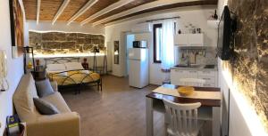 eine Küche und ein Wohnzimmer mit Sofa und Tisch in der Unterkunft Ninfa Alghero in Alghero