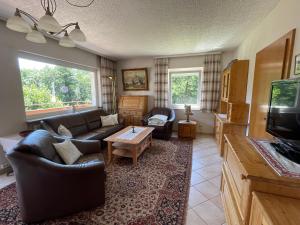 a living room with a couch and a tv at Seeappartement LUNA am Ossiachersee in Bodensdorf
