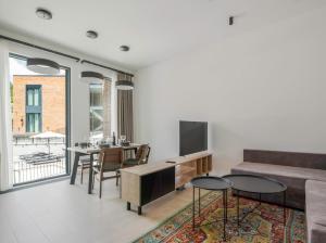 a living room with a couch and a tv and a table at Aurora Luxe in Dilijan