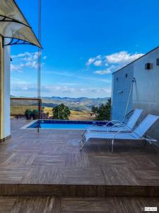 un par de sillas sentadas en la cubierta de una casa en Horizonte de Lavras, en Lavras Novas 6 fotos más