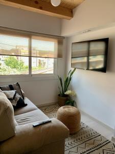 a living room with a couch and two windows at Flat in Girona City Centre - 5 mins from Old Town and Train Station in Girona