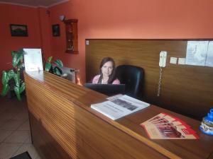 a woman sitting at a desk with a laptop at Penzion Premona in Nitra