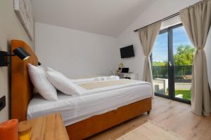 a bedroom with a bed and a large window at Modern 300m2 Villa - King Beds & Leisure Zone in Tinjan