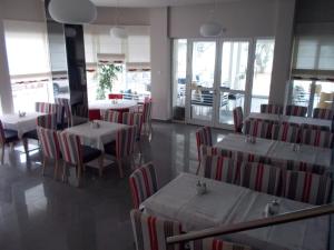 a dining room with tables and chairs in a restaurant at Tokalis Boutique Hotel & Spa in Nea Anchialos