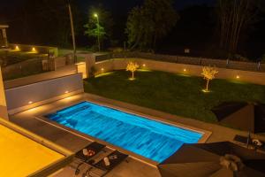 a swimming pool in a backyard at night at Modern 300m2 Villa - King Beds & Leisure Zone in Tinjan +74 photos