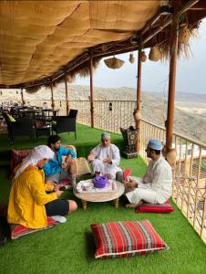 a group of people sitting on the grass under a pavilion at Al Misfah Hospitality Inn in Misfāh