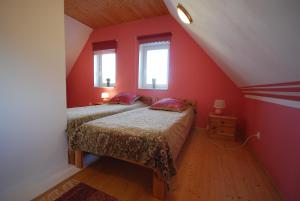 2 bedden in een zolderkamer met rode muren bij Ida Majutus in Kuressaare