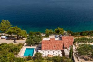 an aerial view of a house and the ocean at Seafront Stone Villa in Blato