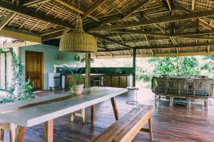 un comedor con una gran mesa de madera y bancos en Eden, en El Nido
