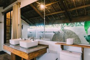 Un baño con dos lavabos y un inodoro. en Eden, en El Nido