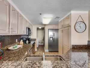 a kitchen with marble counter tops and a clock on the wall at Jade East Towers 0730 by Newman-Dailey in Destin +4 photos