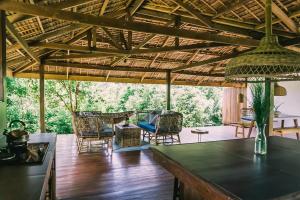 una gran sala de estar con techo de madera y sillas. en Eden, en El Nido 34 fotos más