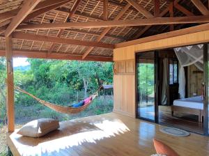 una hamaca en una habitación con una cama y una ventana en Eden, en El Nido