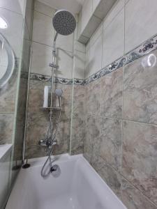 een douche met een douchekop in de badkamer bij Clau Home in Hunedoara