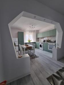 a kitchen with green cabinets and a table and chairs at Clau Home in Hunedoara +12 photos