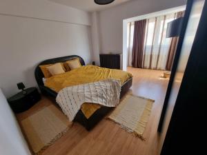 a bedroom with a bed with a yellow comforter at Clau Home in Hunedoara