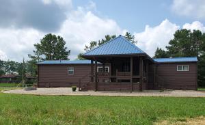 a large wooden cabin with a blue roof at Luxury Cabin w/ Game Room & Hot Tub at Cave Run Lake in Wellington
