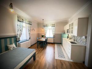 a bedroom with a bed and a kitchen with a table at TGM Apartments in Český Krumlov