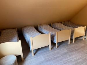 une rangée de 4 lits dans une chambre dans l'établissement Guest house Elernes Muiža, à Daugavpils
