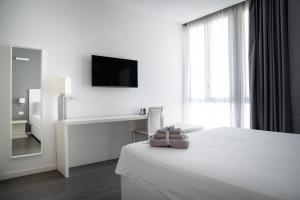 Habitación blanca con cama y TV en Midnight in Genova, en Génova