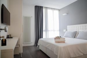 Midnight in Genova في جينوا: غرفة نوم بيضاء مع سرير أبيض ونافذة