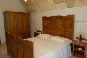 1 dormitorio con 1 cama grande y armarios de madera en B&B Parco del Lamione, en Gioia del Colle