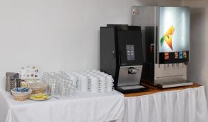 a table with a white table cloth and a machine at Mikulov Inn - Apartments Slunce in Mikulov