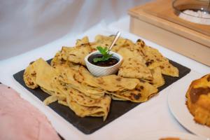 a plate of tortilla chips with a small bowl of salsa at Mikulov Inn - Apartments Slunce in Mikulov