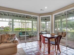 a screened in porch with a table and chairs at Hidden Dunes Villa 44 in Destin