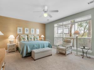 a bedroom with a bed and a chair and a window at Hidden Dunes Villa 44 in Destin