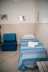 Cette petite chambre comprend deux lits et une chaise. dans l'établissement Vacanze al San Domenico, à Mola di Bari