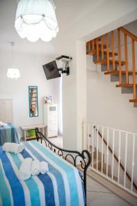 - une chambre dotée d'un lit avec une couverture rayée bleue et blanche dans l'établissement Vacanze al San Domenico, à Mola di Bari