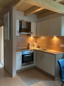 a kitchen with white cabinets and a stove top oven at Villa Toskana Wohnung 1 in Wackersdorf