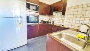 a kitchen with a sink and a white refrigerator at Luxury 2-bed apartment minutes to downtown in Nicosia