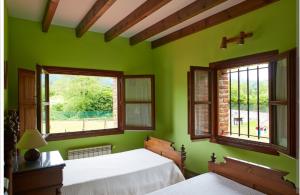 1 dormitorio verde con 2 camas y 2 ventanas en Rotella de xuan, en Llames de Pría