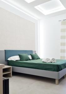 una camera da letto con letto, lenzuola e cuscini verdi di RossHouse a Sorrento