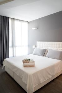 - une chambre blanche avec un grand lit blanc et une fenêtre dans l'établissement Midnight in Genova, à Gênes