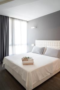 a white bedroom with a large white bed with a window at Midnight in Genova in Genova