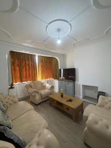 uma sala de estar com um sofá e uma mesa de centro em 3 bedroom house in Sutton em Morden